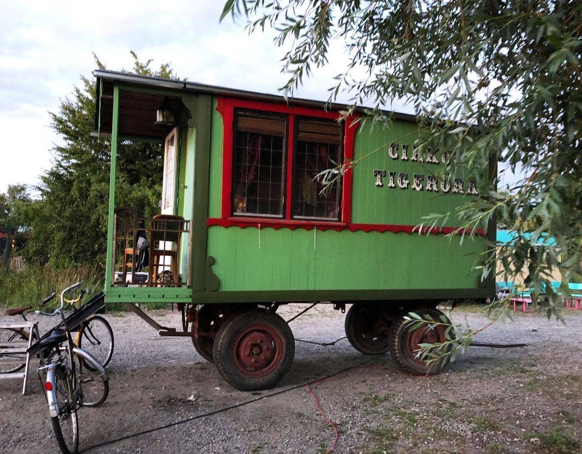 A green cart with a bicycle parked next to it.
