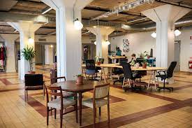 A large open office with tables and chairs.